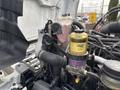 Close-up of the engine compartment of a 2017 Hino 338 showing hoses filters and a coolant reservoir