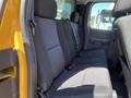 The interior of a 2013 Chevrolet Silverado 1500 showing the back seat with black fabric upholstery and seat belts