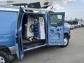 A blue 2010 Ford Econoline van with open side doors revealing tools and equipment inside