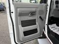 Interior door panel of a 2014 Ford Econoline featuring a grey design with a handle and speaker grill