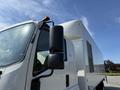A 2024 Isuzu FVR truck is shown from a low angle focusing on the side mirror and cab with a large white cargo box behind it