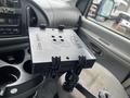 A mounted RAM Tough Tray with various holes for attachments, positioned on a vehicle's dashboard near cup holders and controls