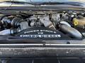 An open engine bay of a 2008 Ford F-550 displaying a Power Stroke V8 Turbo Diesel engine with various components and hoses visible
