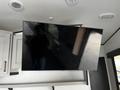 A large mounted flat-screen television displayed at an angle on a wall inside a recreational vehicle