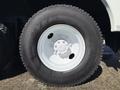 Close-up of a large black tire mounted on a white wheel with visible tread markings and the text N775 on the sidewall