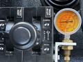 Control panel of a 2017 International WorkStar 7600 featuring levers for truck hoist and gauges for monitoring pressure and operation levels