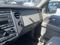 Interior dashboard of a 2013 Ford Expedition with controls for audio and climate settings and a view of the side mirror