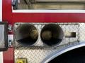 Close-up of a 2006 Emergency One Fire Truck showing two large, round hose compartments with a textured interior and a metal exterior