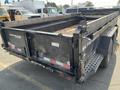 A 2024 Southland SL716-20K dump trailer with a black metal body and a textured surface, featuring a hinged tailgate and side rails for cargo containment