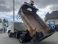A 2008 Mitsubishi Fuso FE180 dump truck is shown with its bed raised, revealing a rusted interior and a hydraulic lift mechanism
