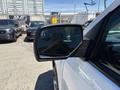 A side view mirror of a 2016 GMC Sierra 1500 showing a reflection of a person and vehicles in the background