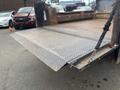 A 2008 Mitsubishi Fuso FE180 with a flatbed truck design featuring a diamond plate ramp extended at the rear