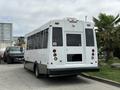A white 2020 Chevrolet Express bus with large windows and a rear door, designed for passenger transport, parked on a concrete surface