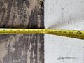 A yellow measuring tape is laid flat against a surface with numbers visible up to 107 inches
