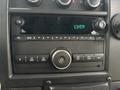 The dashboard controls of a 2020 Chevrolet Express featuring a radio display with various buttons and knobs for settings and tuning