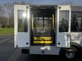 A 2018 Chevrolet Express with its rear doors open revealing a yellow motorized wheelchair lift inside