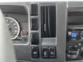 Close-up of the dashboard controls of a 2018 Isuzu NRR displaying speedometer gear controls and various buttons for air conditioning and vehicle functions