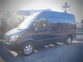 A blue 2017 Mercedes-Benz Sprinter van with a high roof and large side windows parked on a flat surface