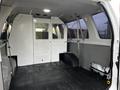 Interior of a 2011 Ford Econoline with a spacious cargo area and a partition separating the driver from the load space