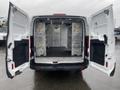 A 2018 Ford Transit van with its rear doors open revealing a spacious interior designed for cargo transport