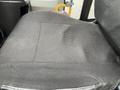 A close-up view of the driver seat of a 2017 Chevrolet Express showing a textured fabric surface with some wear and visible creases