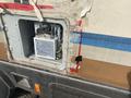 Close-up of an open panel on a 1987 Chevrolet Fleetwood Pace Arrow revealing internal components and wiring inside the vehicle