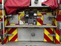 The rear control panel of a 2009 Spartan Gladiator fire truck featuring various gauges buttons and warning lights in a red and yellow chevron pattern
