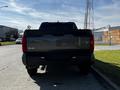 Rear view of a 2023 Toyota Tundra with a bold TUNDRA logo and dual exhaust pipes showcasing its robust design and 4x4 capability