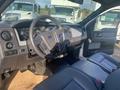 Interior view of a 2013 Ford F-150 emphasizing the dashboard and front seats with a focus on controls and the steering wheel