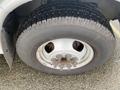 Close-up of a Chevrolet Express wheel featuring a silver rim and a black tire with visible tread patterns