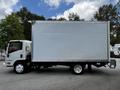 A 2018 Isuzu NPR truck with a large blank white box cargo area and a cab with a driver seat visible on the left side