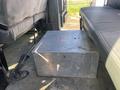 A silver metal storage box is positioned between the seats of a 2014 International 7400 truck interior