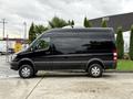 A black 2017 Mercedes-Benz Sprinter van is parked with its side profile visible showcasing large windows and a sleek design
