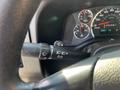 A close-up view of the steering column controls of a 2014 Chevrolet Express including the wiper and headlight controls