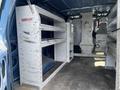 A 2009 Ford Econoline van interior featuring white storage shelves and organizational units designed for tools and equipment