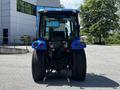 A blue 2018 New Holland Boomer 45 tractor viewed from the rear with large tires and a cabin featuring a clear windshield and dashboard