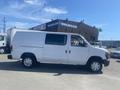 A white 2009 Ford Econoline van with a sliding side door and standard wheels parked in profile view