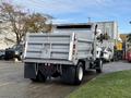 A white 2011 International WorkStar truck with a silver dump bed is parked, showing its rear and a large hitch attachment