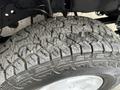 Close-up of a rugged tire with deep treads mounted on a wheel of a 2001 Ford F-350