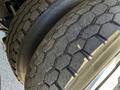 Close-up of a tire from a 2005 Volvo VND 122 showing a worn tread pattern and visible dirt on the rubber surface