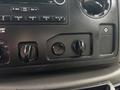 The image shows the control panel of a 2014 Ford E-350 with various knobs and buttons for adjusting audio and climate settings