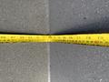 A yellow measuring tape laid out flat showing various measurements in inches