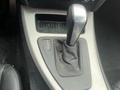 Close-up of the gear shift in a 2011 BMW 3-Series showing the P R N D layout and leather boot