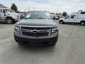 A gray 2016 Chevrolet Tahoe is parked facing the viewer with a prominent front grille and headlights visible