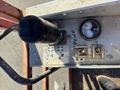 Control panel of a 2010 SkyJack SJ featuring a joystick a gauge and toggle switches with labels