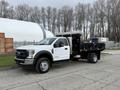 A 2021 Ford F600 truck in white with a black flatbed designed for heavy-duty work and equipped with toolboxes on either side