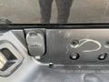 Close-up of a 2015 RAM 1500 tailgate with a trailer wiring connector on the left side and several mounting holes visible on the surface