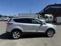 A silver 2014 Ford Escape parked with its side view visible showcasing its sleek design and modern features