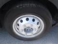 Close-up of a silver wheel and tire of a 2016 Ford Transit featuring multiple holes in the wheel rim and a black tread on the tire