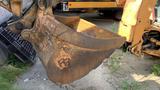 Close-up of a rusty bucket attachment from a 2015 Case 580 construction excavator showing worn edges and a textured surface